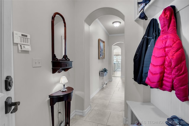 mudroom featuring light tile patterned floors and ornamental molding