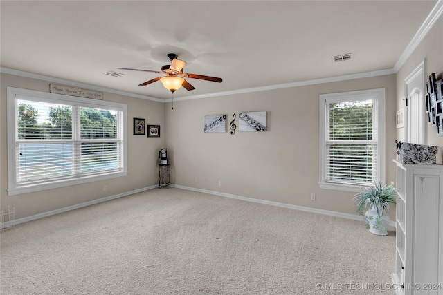 carpeted spare room featuring crown molding and ceiling fan