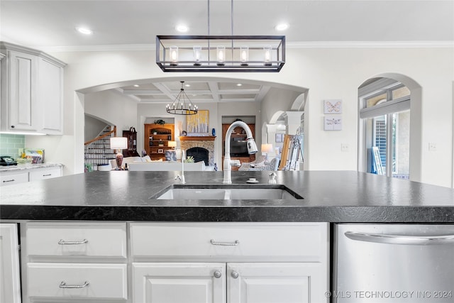 kitchen featuring crown molding, stainless steel dishwasher, white cabinetry, and sink