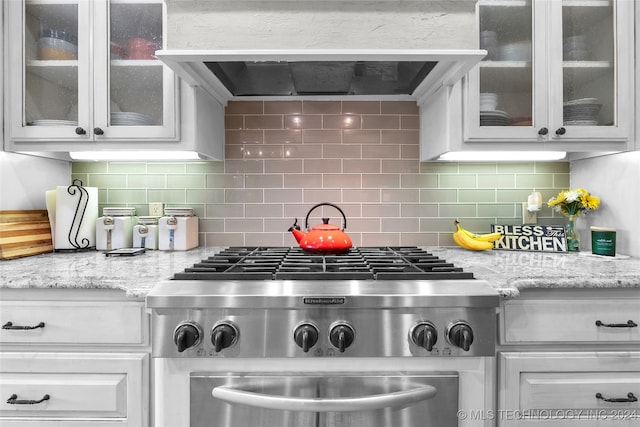 kitchen featuring white cabinets, stainless steel range, and tasteful backsplash