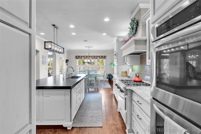 kitchen featuring backsplash, white cabinetry, appliances with stainless steel finishes, and sink