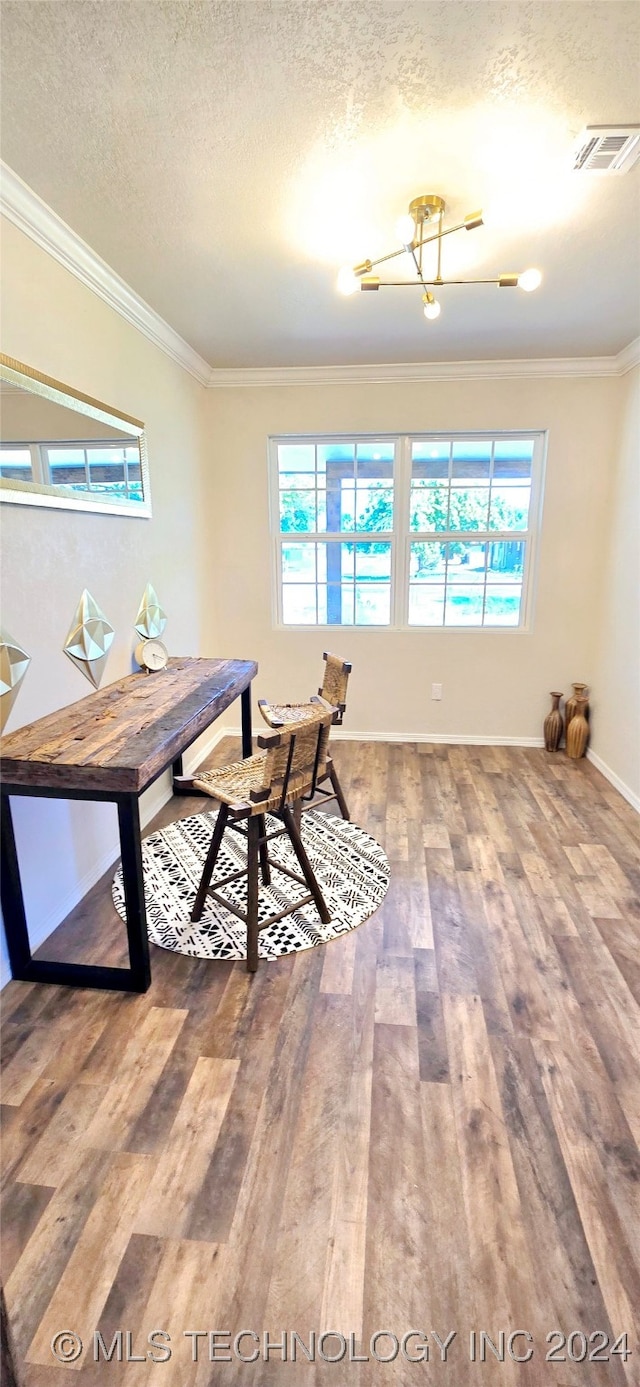 dining space with ornamental molding, a textured ceiling, plenty of natural light, and hardwood / wood-style floors