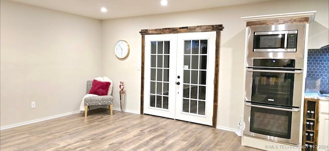 interior space featuring stainless steel appliances, light wood-type flooring, and french doors