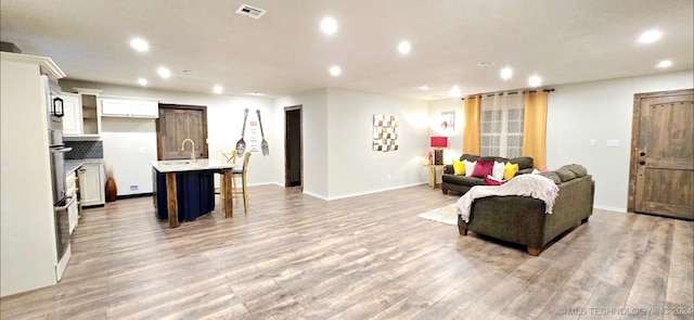 living room featuring light hardwood / wood-style floors and sink