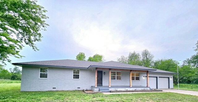 single story home featuring a garage, a porch, and a front lawn