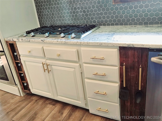 interior space featuring white cabinetry, hardwood / wood-style flooring, and tasteful backsplash