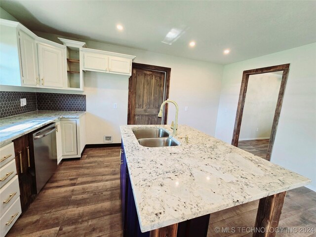 kitchen featuring dark wood-type flooring, tasteful backsplash, a center island with sink, stainless steel dishwasher, and sink