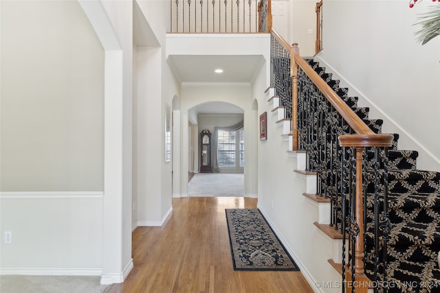 foyer entrance with wood-type flooring and crown molding