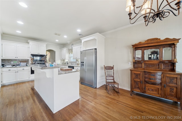 kitchen featuring light wood-type flooring, a notable chandelier, white cabinetry, a kitchen island, and appliances with stainless steel finishes