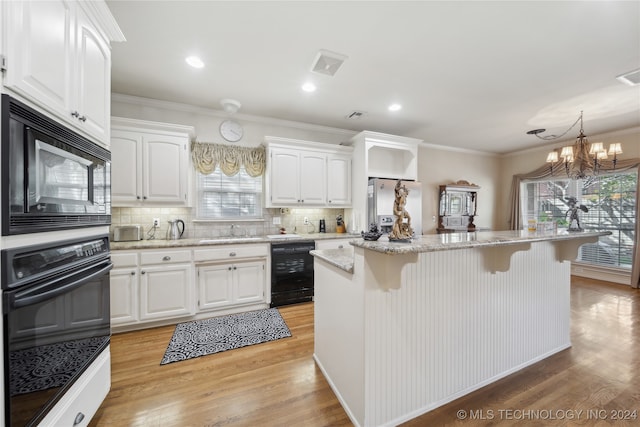 kitchen featuring white cabinets, a center island, plenty of natural light, and black appliances