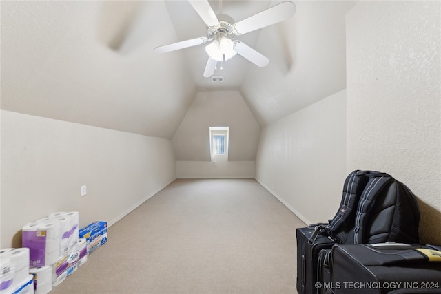 interior space featuring ceiling fan, lofted ceiling, and light carpet