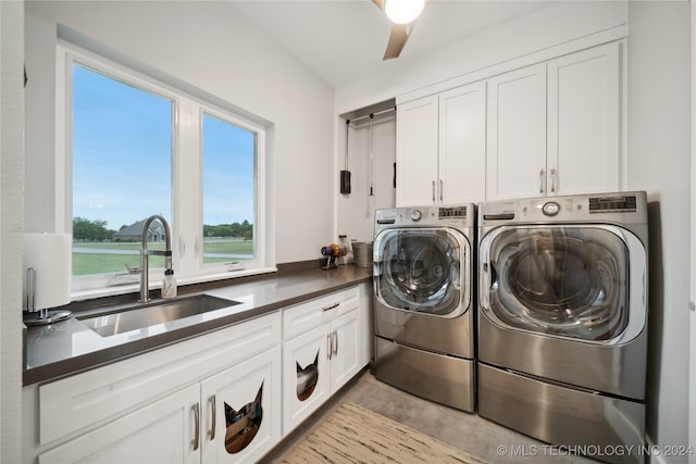 clothes washing area with cabinet space, ceiling fan, washer and dryer, and a sink