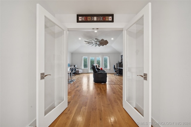 hallway with lofted ceiling, light wood-style floors, baseboards, and recessed lighting