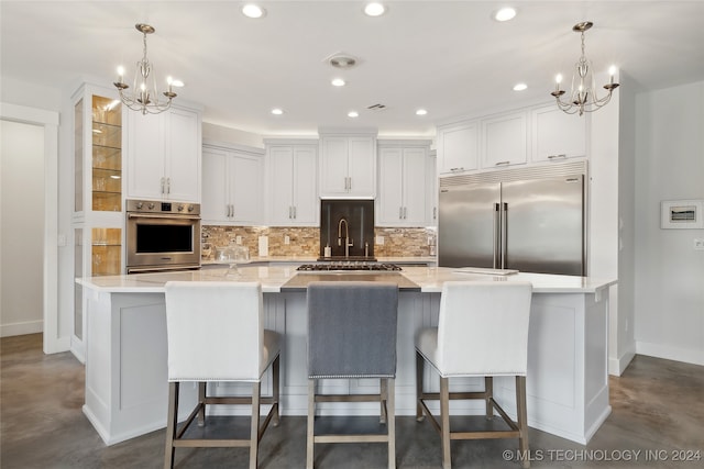 kitchen with appliances with stainless steel finishes, white cabinets, a large island, and tasteful backsplash