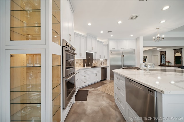 kitchen with light stone counters, stainless steel appliances, white cabinets, decorative backsplash, and glass insert cabinets