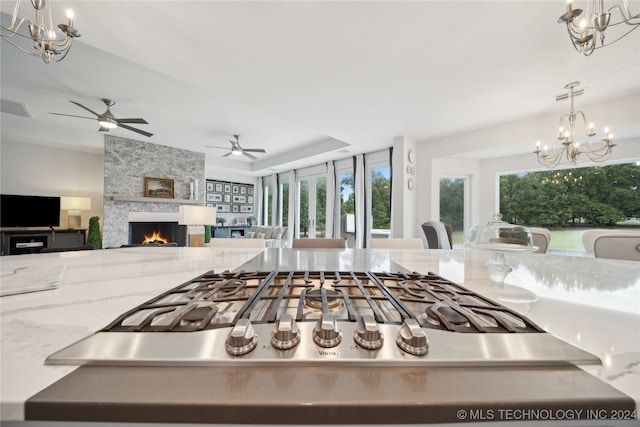 kitchen with visible vents, stainless steel gas cooktop, open floor plan, and a notable chandelier