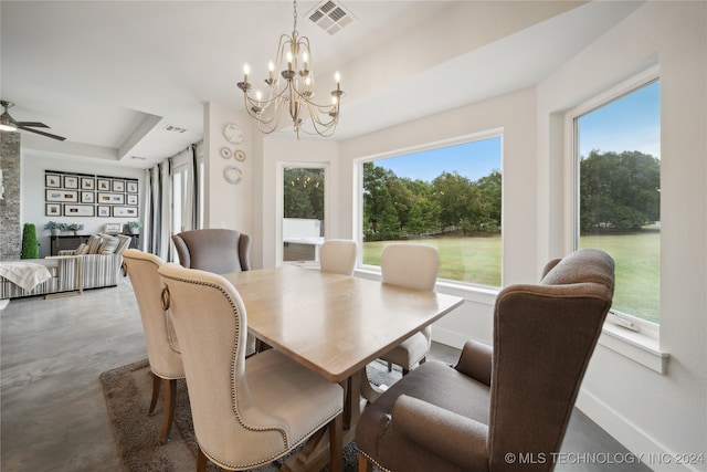 dining area featuring concrete flooring, a tray ceiling, visible vents, and baseboards