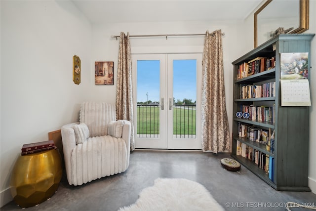 sitting room with finished concrete flooring and french doors