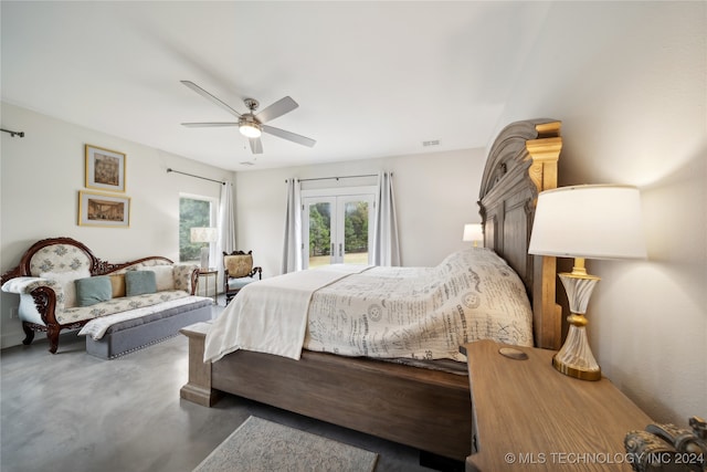 bedroom with french doors, visible vents, concrete floors, and ceiling fan