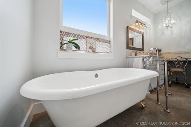 bathroom with a freestanding bath, concrete floors, and an inviting chandelier