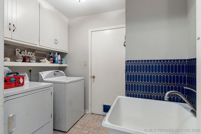 clothes washing area with cabinets, washing machine and dryer, and light tile patterned floors