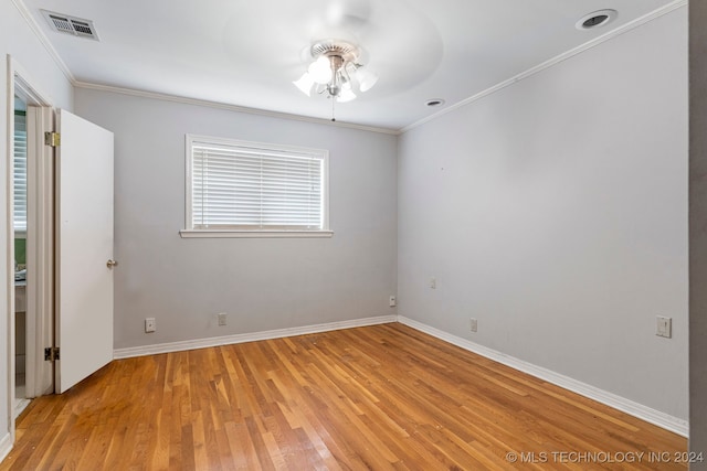 spare room with ceiling fan, crown molding, and light wood-type flooring