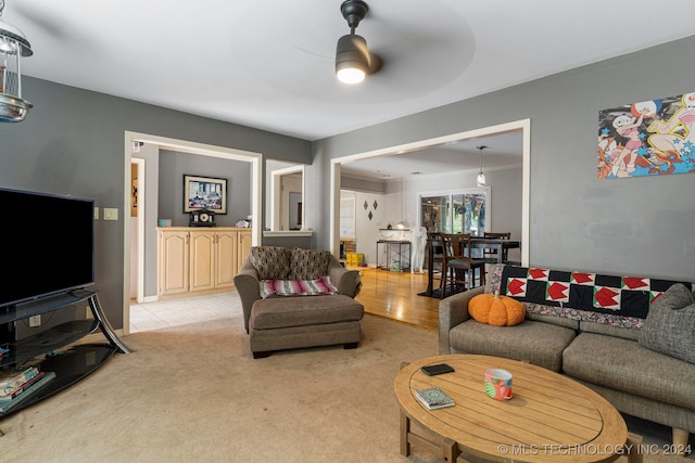 carpeted living room with ceiling fan