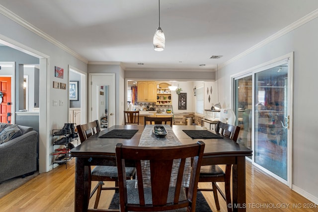 dining area featuring ornamental molding and light wood-type flooring