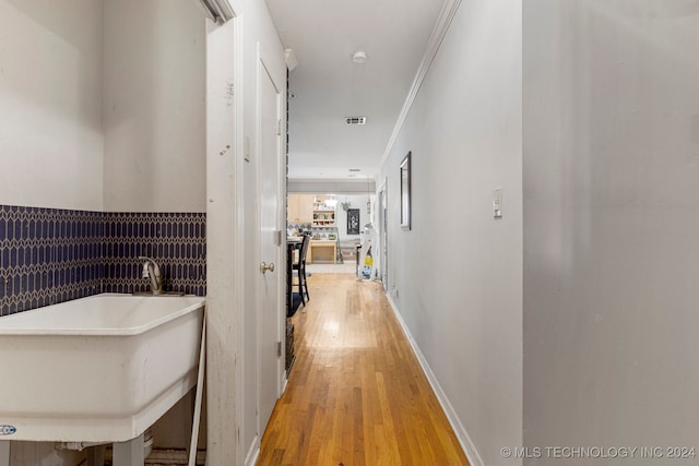 hallway featuring ornamental molding, sink, and wood-type flooring