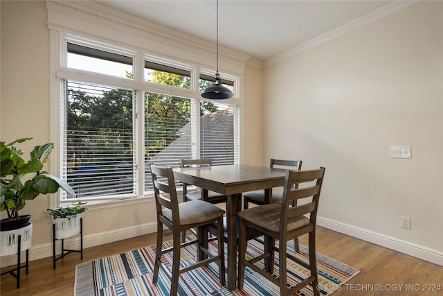 dining space with ornamental molding and hardwood / wood-style flooring