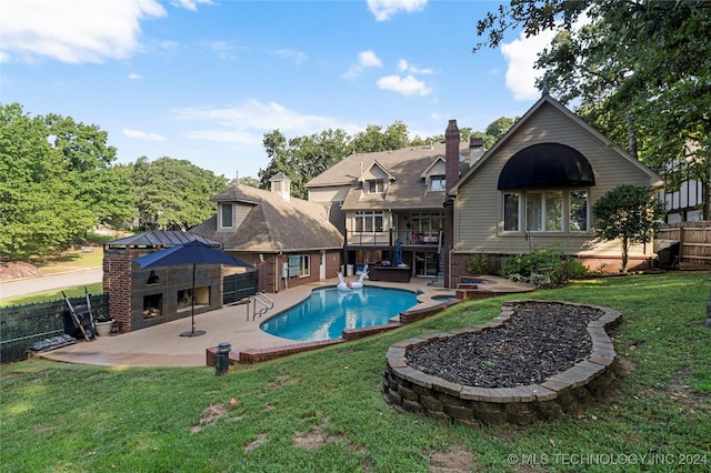 view of pool featuring a patio, a fireplace, and a lawn