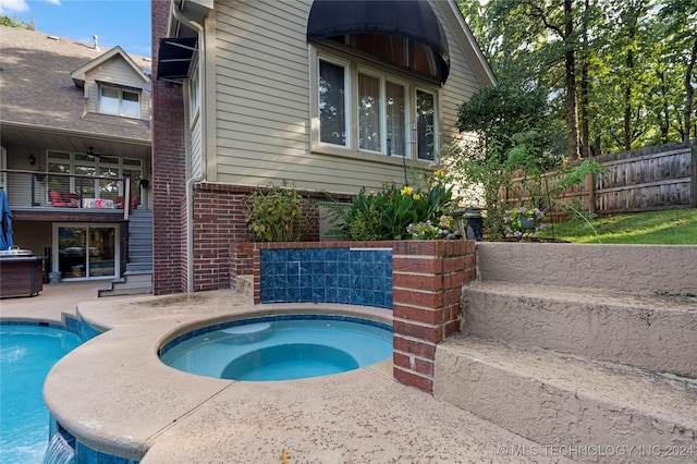 view of swimming pool with an in ground hot tub