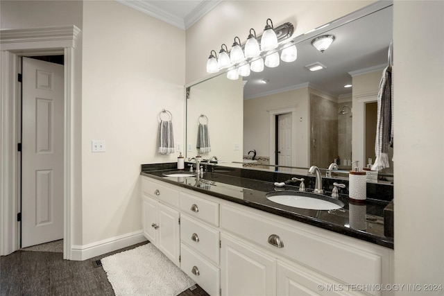 bathroom featuring tiled shower, hardwood / wood-style floors, crown molding, and vanity