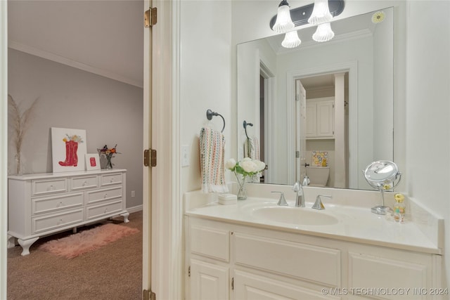 bathroom with toilet, vanity, and ornamental molding