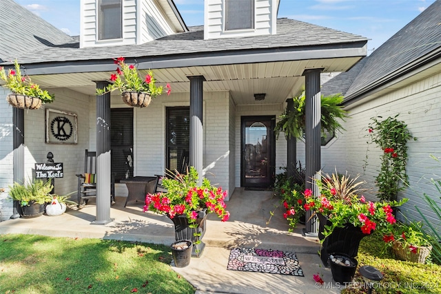 view of exterior entry featuring covered porch