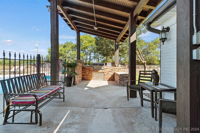 view of patio featuring an outdoor kitchen and a grill