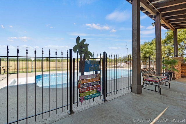 view of gate with a patio and a fenced in pool