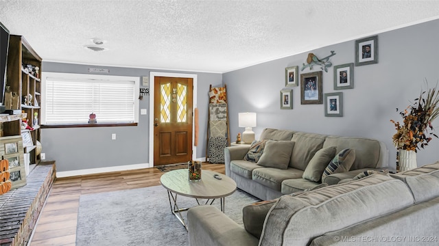 living room with a textured ceiling, hardwood / wood-style floors, and crown molding