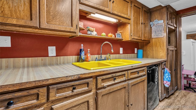 kitchen featuring dishwasher, hardwood / wood-style floors, and sink