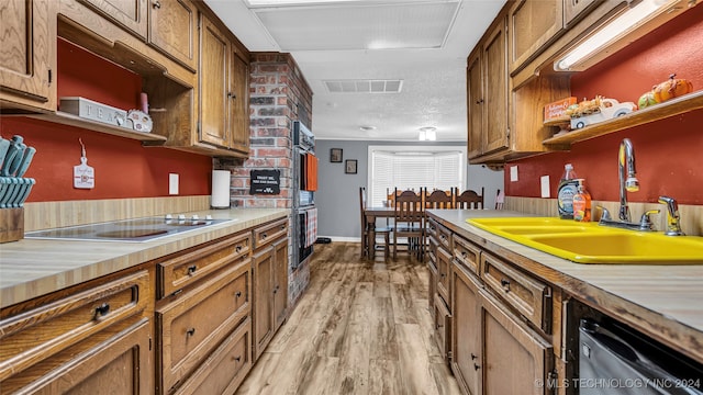 kitchen featuring dishwasher, light hardwood / wood-style floors, electric cooktop, sink, and double oven