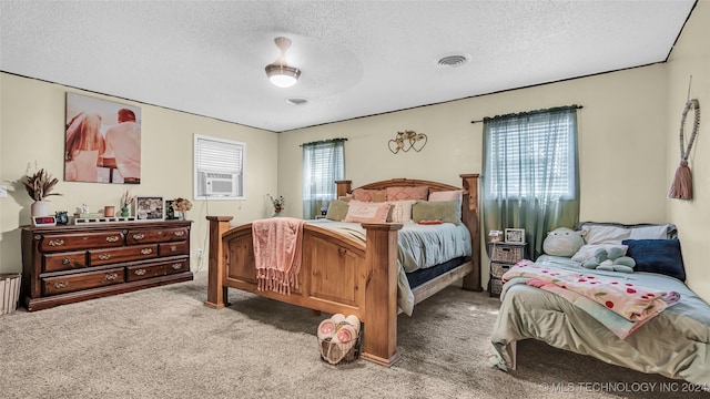 carpeted bedroom featuring cooling unit, a textured ceiling, and ceiling fan