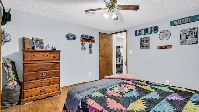 bedroom featuring ceiling fan, a textured ceiling, and light hardwood / wood-style floors