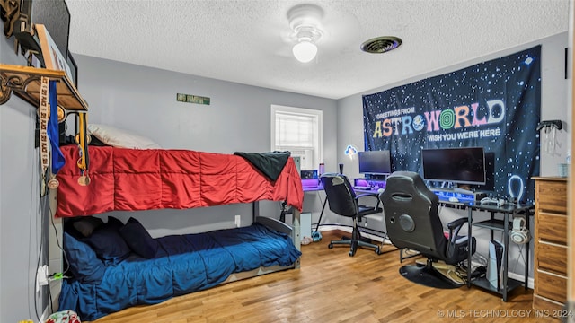 bedroom with hardwood / wood-style flooring and a textured ceiling