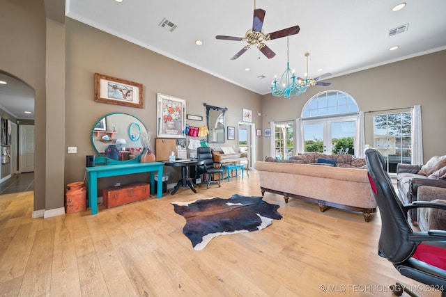 interior space featuring ornamental molding, ceiling fan with notable chandelier, and light wood-type flooring