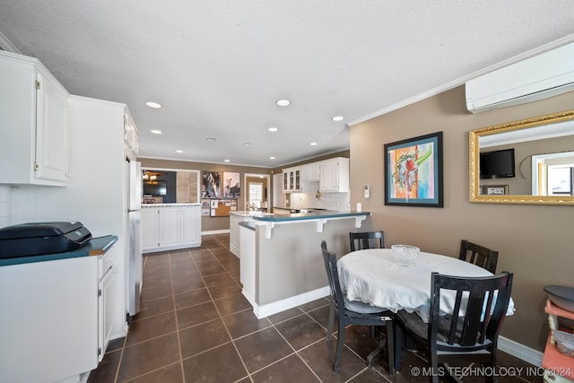 kitchen featuring an AC wall unit, white cabinetry, a kitchen breakfast bar, dark tile patterned floors, and kitchen peninsula