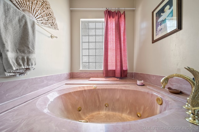 bathroom featuring plenty of natural light and a tub