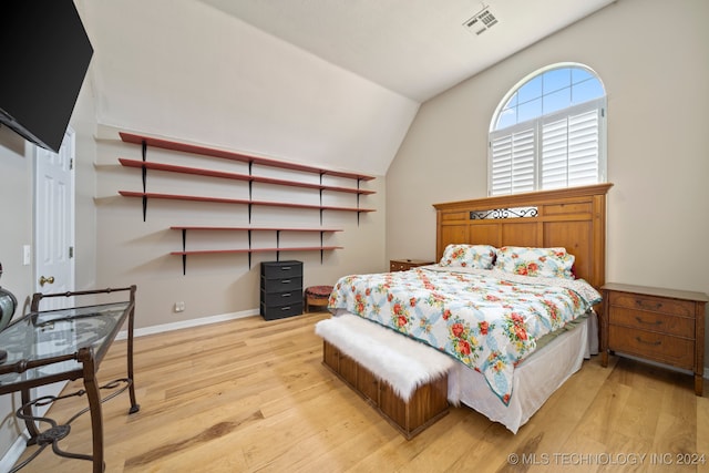 bedroom with vaulted ceiling and light hardwood / wood-style flooring