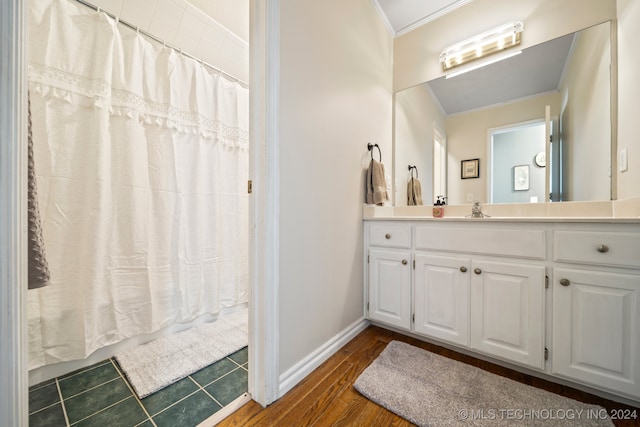 bathroom featuring vanity, crown molding, and hardwood / wood-style flooring