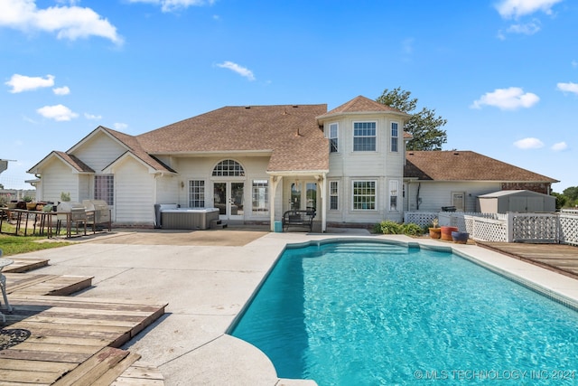 view of swimming pool featuring a hot tub and a patio area