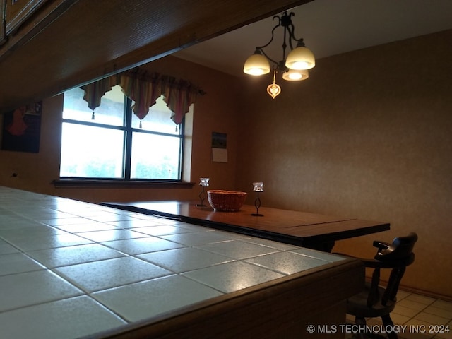 unfurnished dining area with a notable chandelier and tile patterned flooring